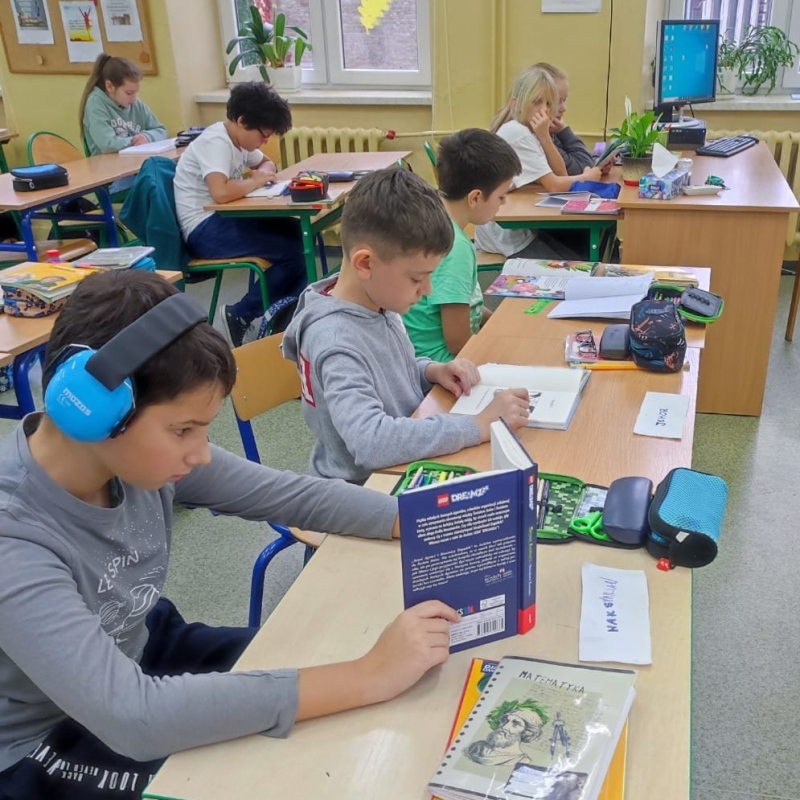 Uczniowie klasy 4 czytający książki