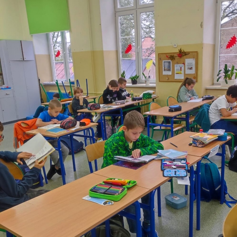 Uczniowie klasy 4 czytający książki