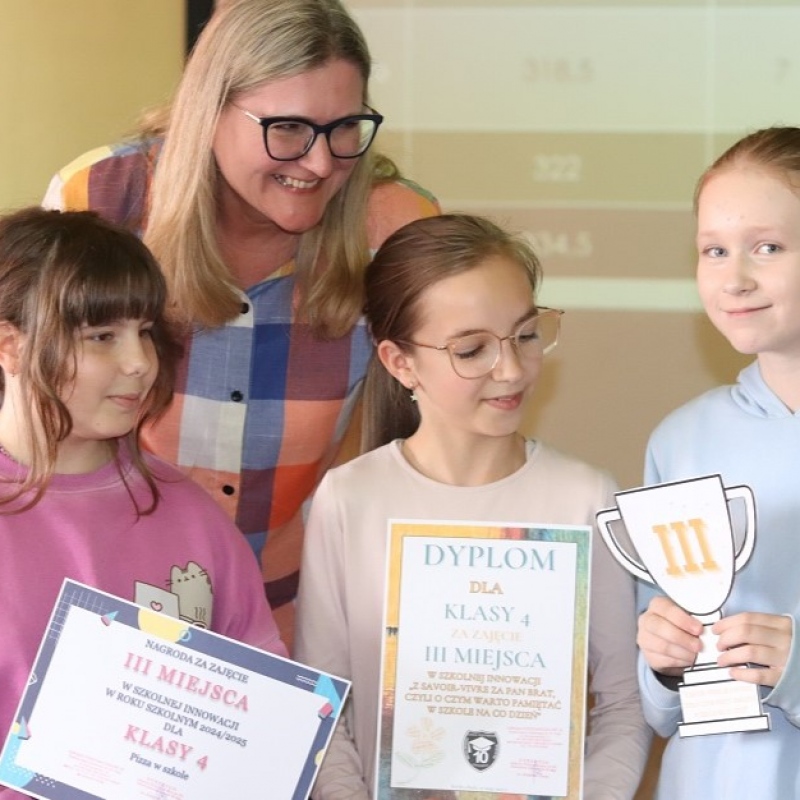 3 uczennice z klasy 4 z dyplomami,papierowym pucharem i nagrodą w ręce i z Panią Dyrektor