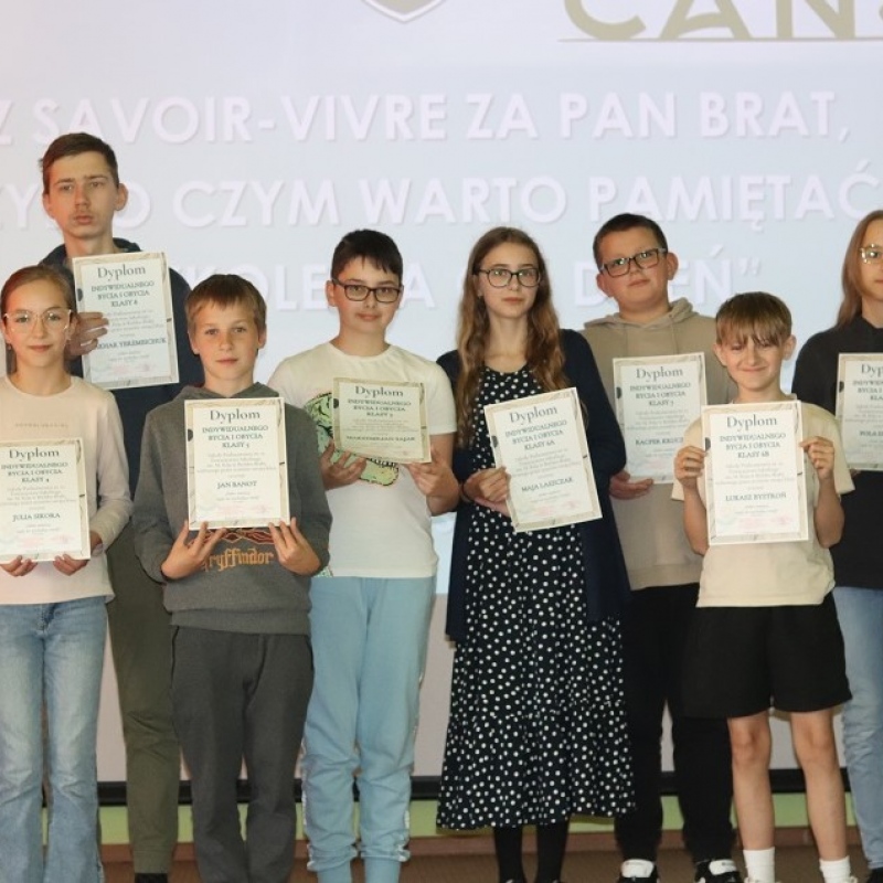 Uczniowie na scenie z dyplomami w ręce