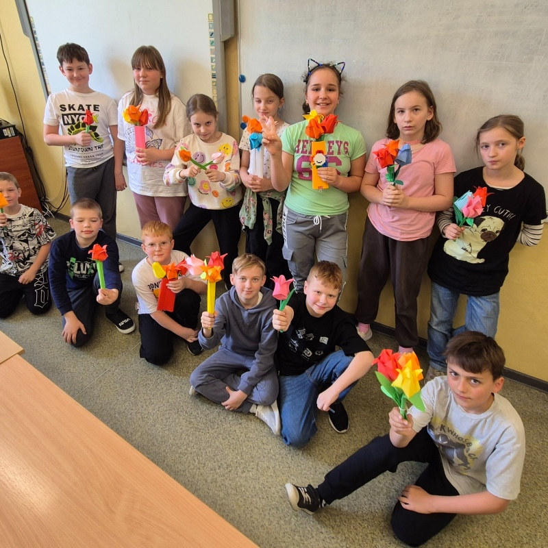 Uczniowie klasy 3b pozują z własnoręcznie zrobionymi tulipanami origami