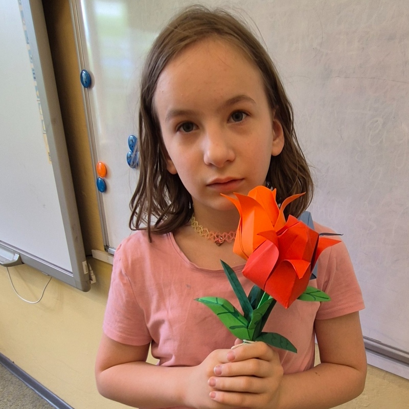 Uczennica klasy 3b pozuje z własnoręcznie zrobionymi tulipanami origami