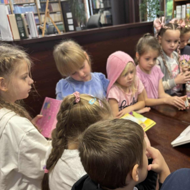 Uczniowie słuchają i patrzą na książki