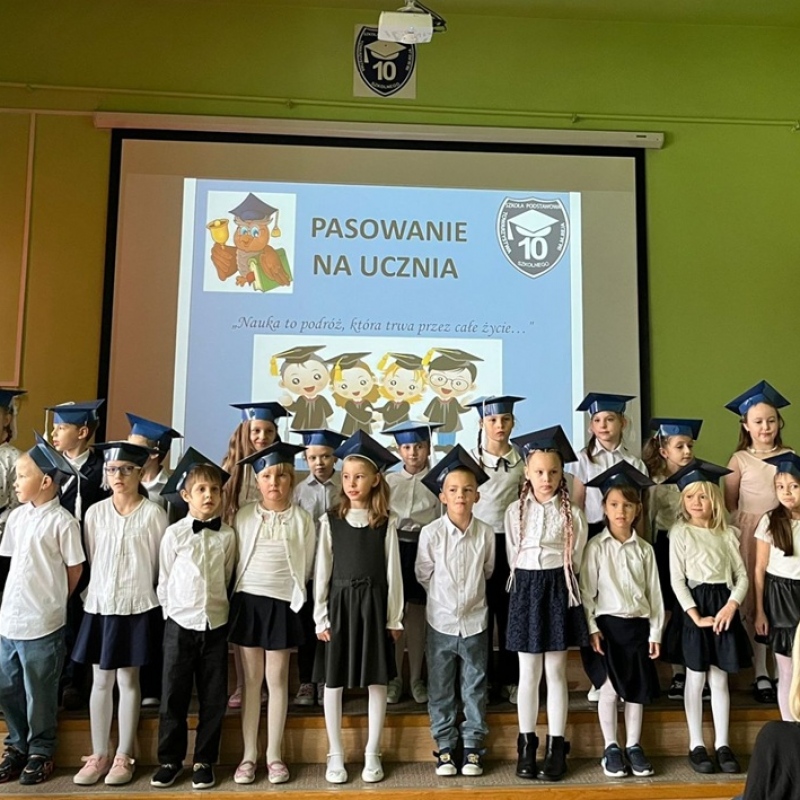 Uczniowie w biretach na podwyższeniu