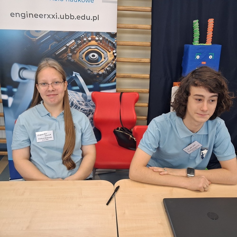 uczniowie w ławce przy laptopie