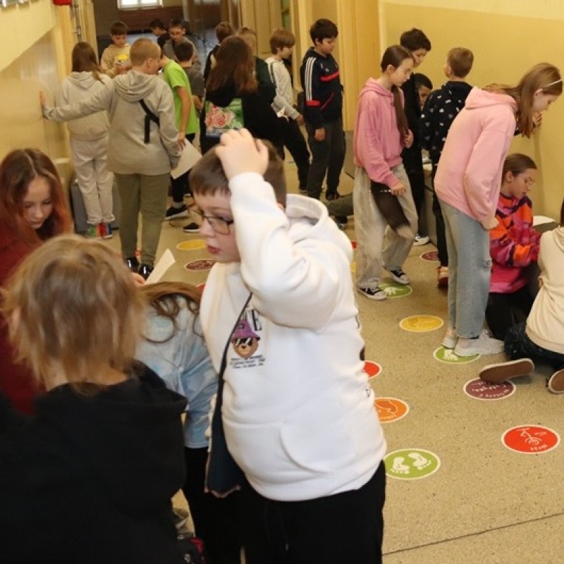 Uczniowie klasy 5 w trakcie wykonywania zadań w grupach i przechodzenia pomiędzy stacjami