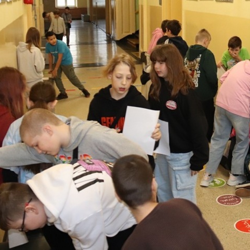 Uczniowie klasy 5 w trakcie wykonywania zadań w grupach i przechodzenia pomiędzy stacjami