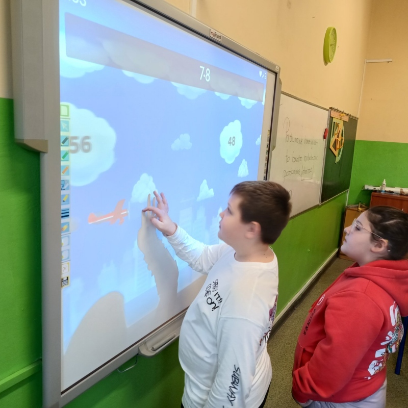 Uczniowie podczas rozwiązywania zadań na tablicy multimedialnej