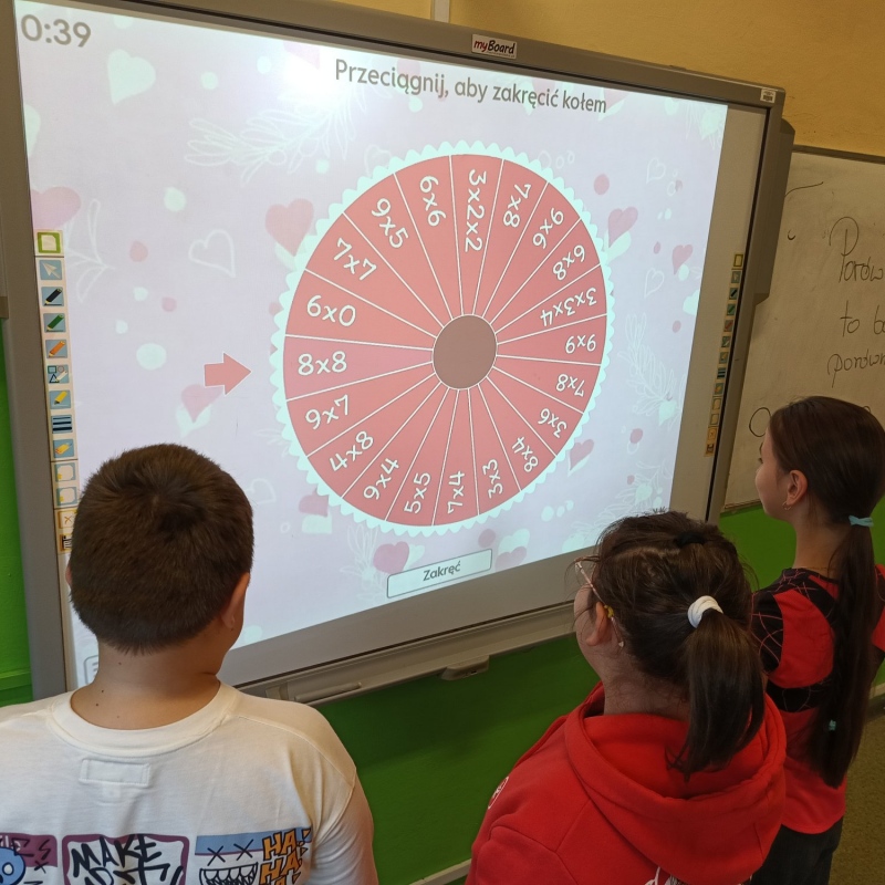 Uczniowie podczas rozwiązywania zadań na tablicy multimedialnej