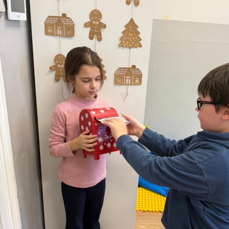 Uczeń wrzuca list do skrzynki świetlicowej uczennica trzyma skrzynkę