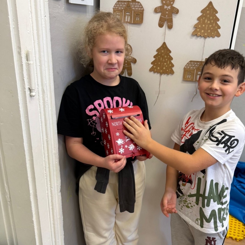 Uczeń wrzuca list do skrzynki świetlicowej uczennica trzyma skrzynkę