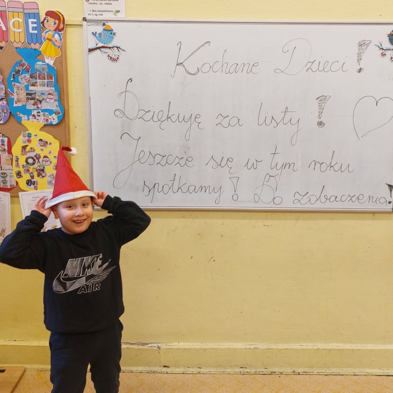 Dziecko z napisem na tablicy od świętego Mikołaja