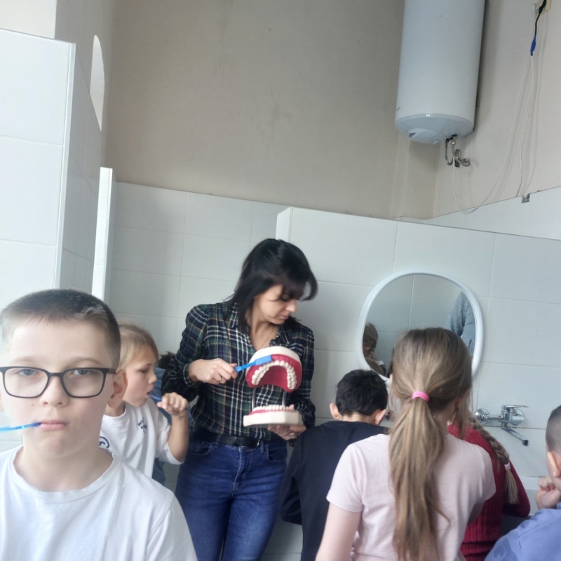 Nauczycielka z uczniami podczas mycia zębów