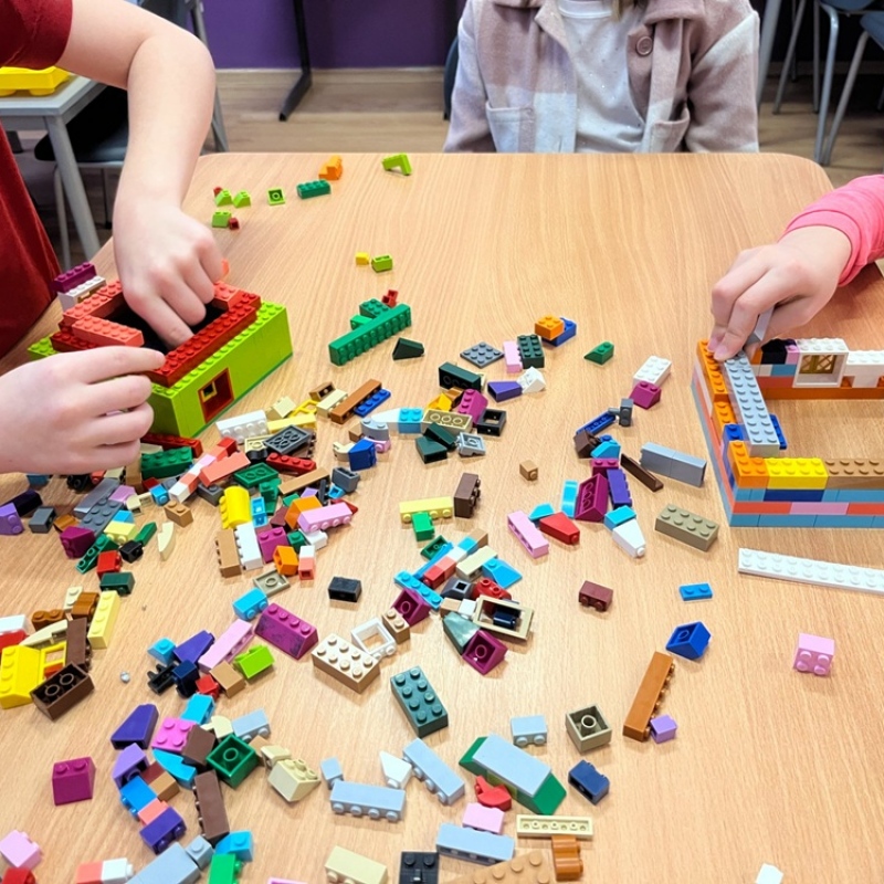 uczniowie budują z klocków lego
