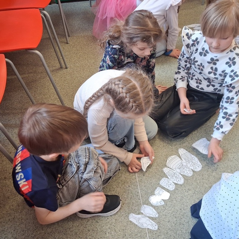 dzieci na podłodze rozwiązują łamigłówki