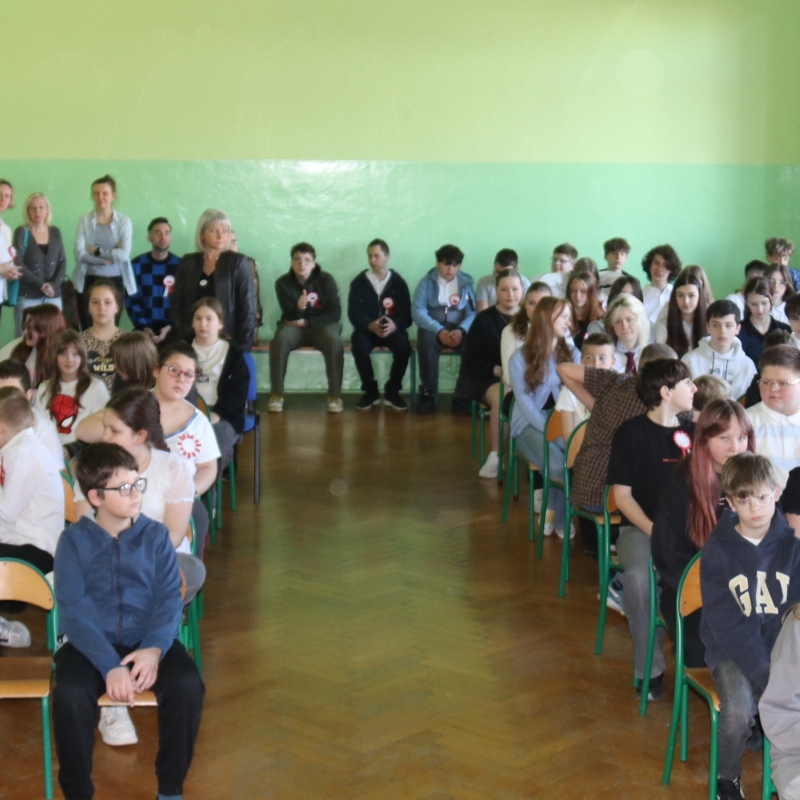 uczniowie siedzą na auli szkolnej