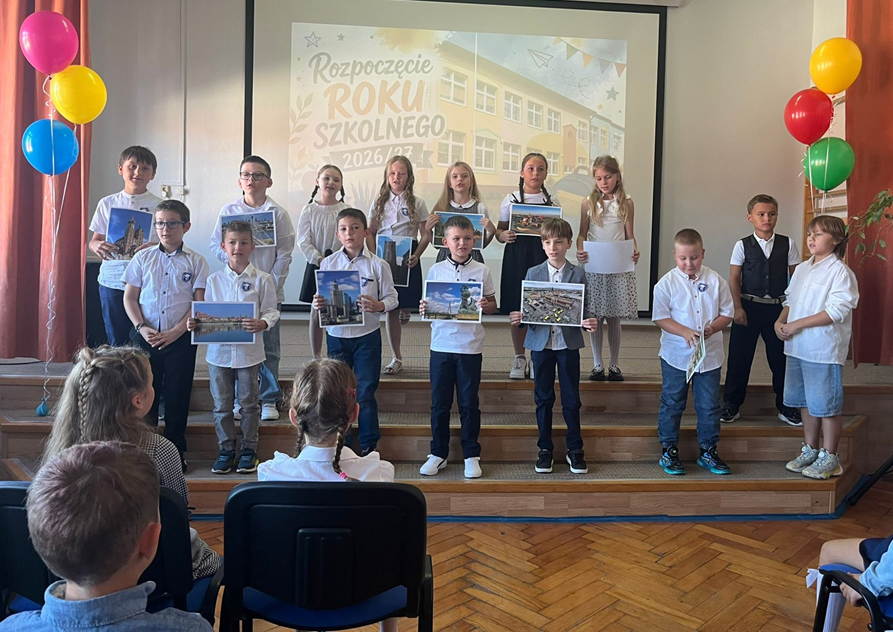 uczniowie na scenie ze zdjęciami z różnych miejsc
