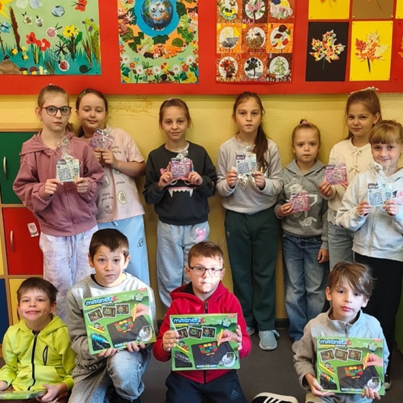 uczniowie klasy pozują do zdjęcia z upominkami w ręku