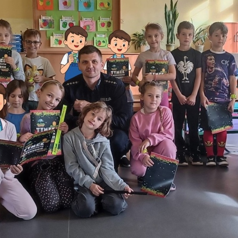 uczniowie całą klasą pozują do zdjęcia z policjantem